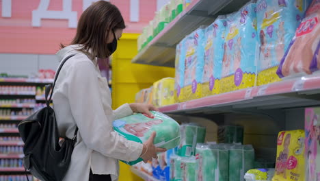 mujer comprando pañales en un supermercado