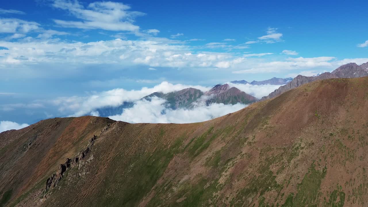 cadena montañosa de kazajstán capturada desde arriba con nubes rodando a través de los picos