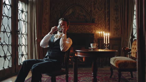 man relaxing with a hot beverage by the fireplace in an elegant room