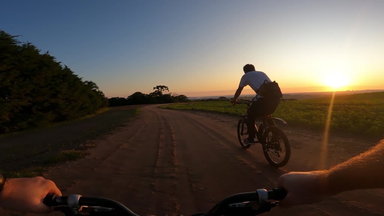 ciclista en una carretera rural al atardecer, toma de cámara de acción