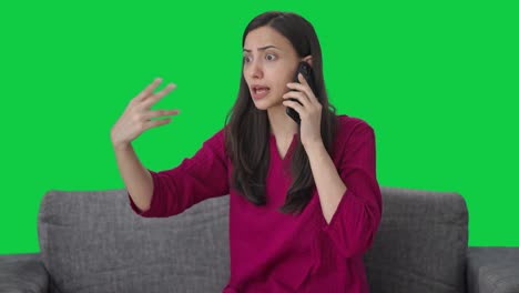 mujer india enojada gritando a alguien en la pantalla verde de llamada