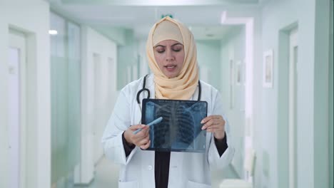muslim doctor checking x ray report to patient