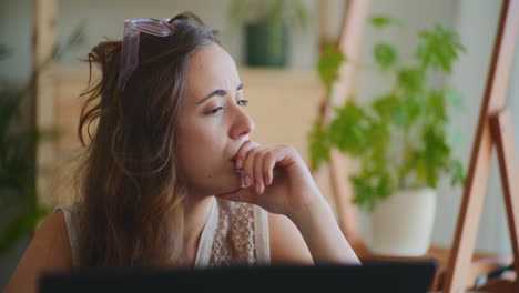 Businesswoman-Contemplating-by-Window-with-Laptop