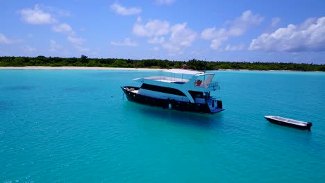 Modern-luxury-yacht-in-clear-turquoise-waters,-pan-around-in-4k