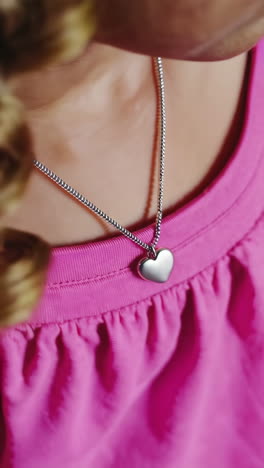 close-up of a child wearing a heart-shaped necklace