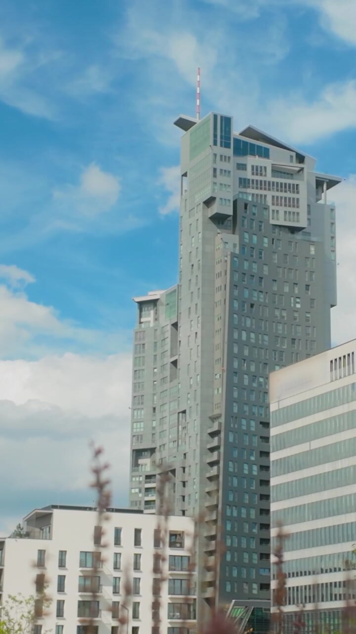 Uma vista em ângulo baixo de arquitetura contemporânea e arranha-céus contra um céu azul, adequada para temas de negócios, mercado imobiliário e desenvolvimento urbano