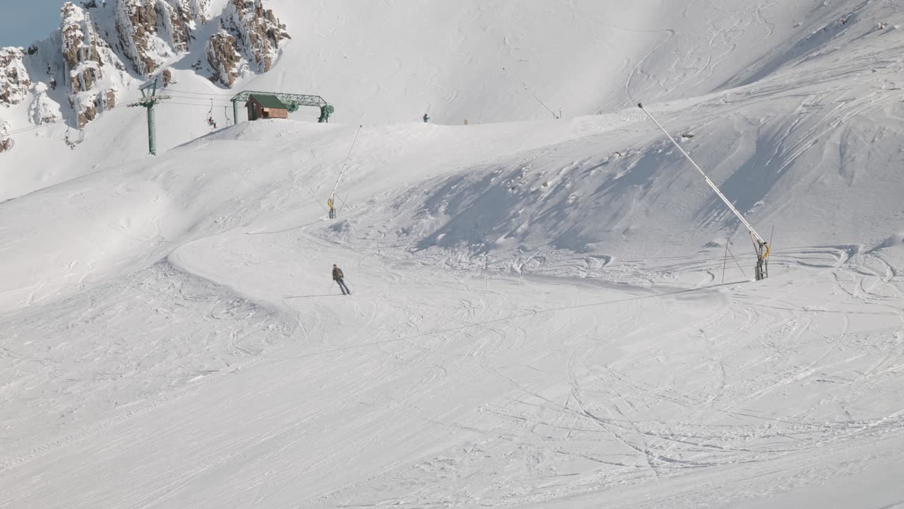 Skier coming down slope from top station of chair lift