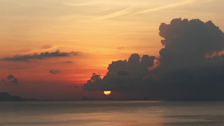 Static shot of yellow sun behind cloudscape over ocean in Koh Samui, Thailand
