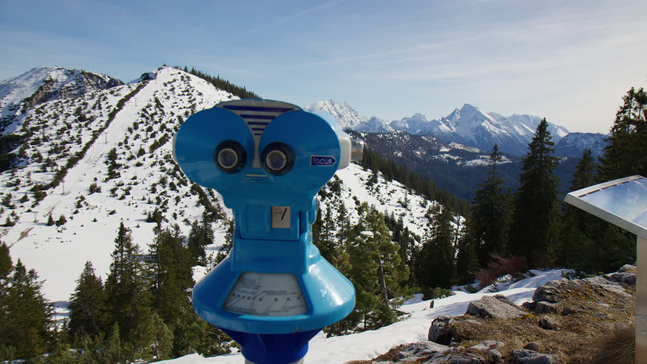 Binoculars Viewer At The Viewpoint With Snowy Mountains In The Background. Wide shot
