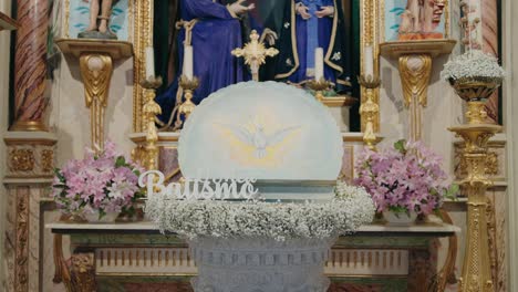 holy baptismal font adorned with dove and vibrant flowers