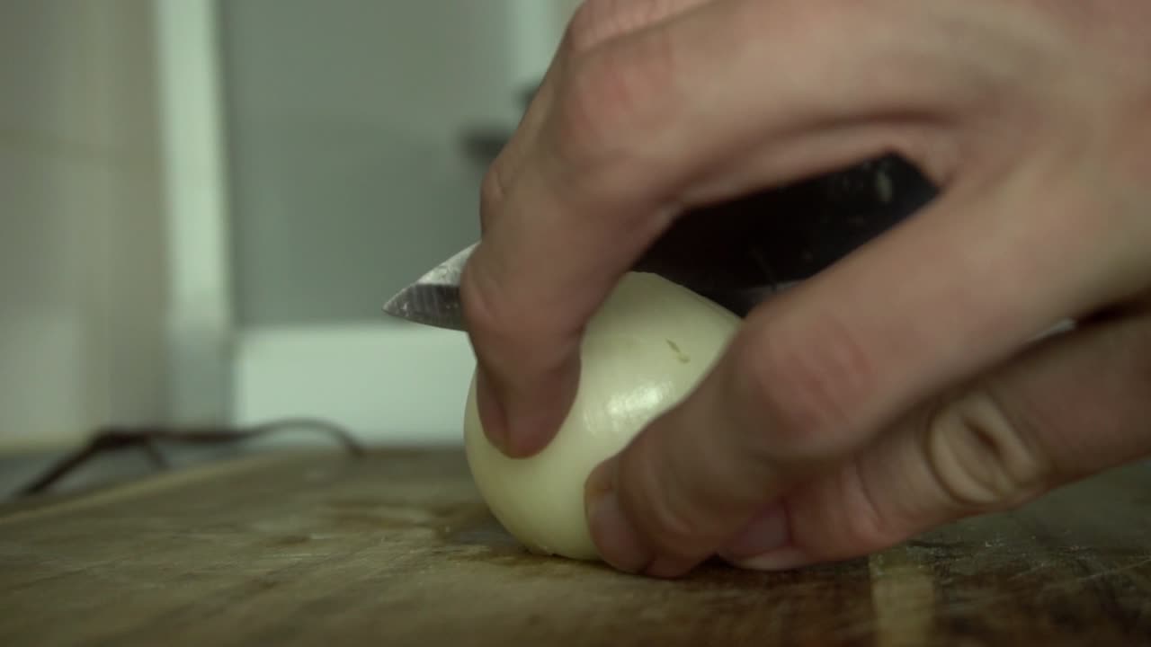 Chopping onion with large kitchen knife, food preparation