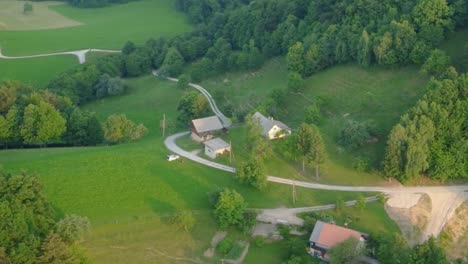 old family houses with barns up in hills surrounded with meadows and green spruce trees