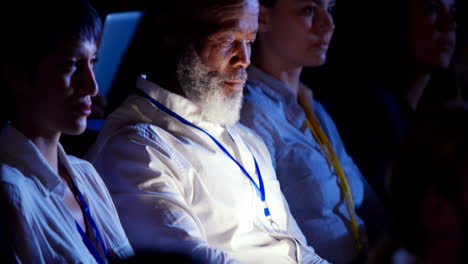 empresario afroamericano usando una computadora portátil durante un seminario en el auditorio 4k