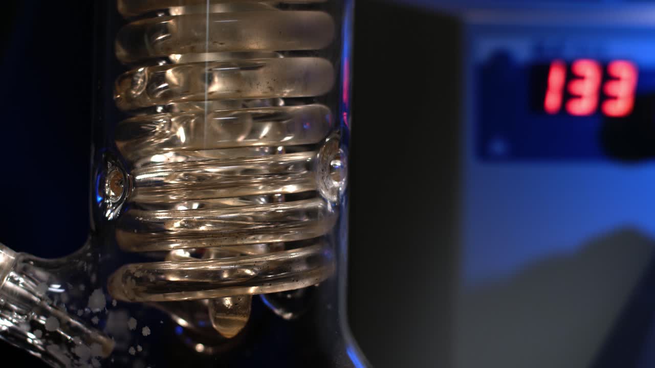 equipo de laboratorio con condensador en espiral y indicador de temperatura