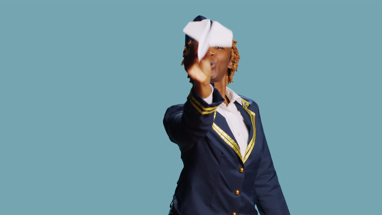 Young stewardess playing with paper airplane