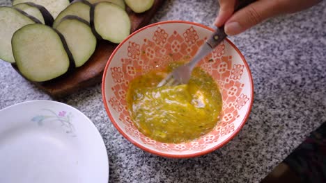 batir huevo fresco con condimentos en un bol con tenedor