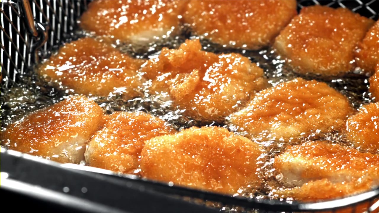 熱い油できつね色に揚がるチキンナゲット