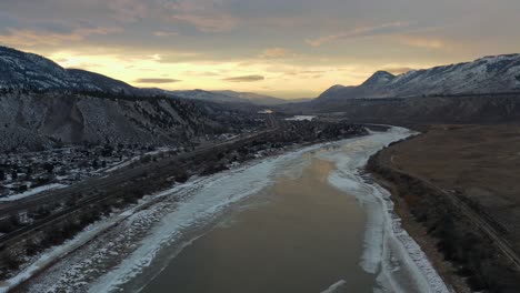 Der-Verschneite-Thompson-River:-Ein-Winterwunderland,-Getaucht-In-Einen-Dramatischen-Sonnenuntergangshimmel