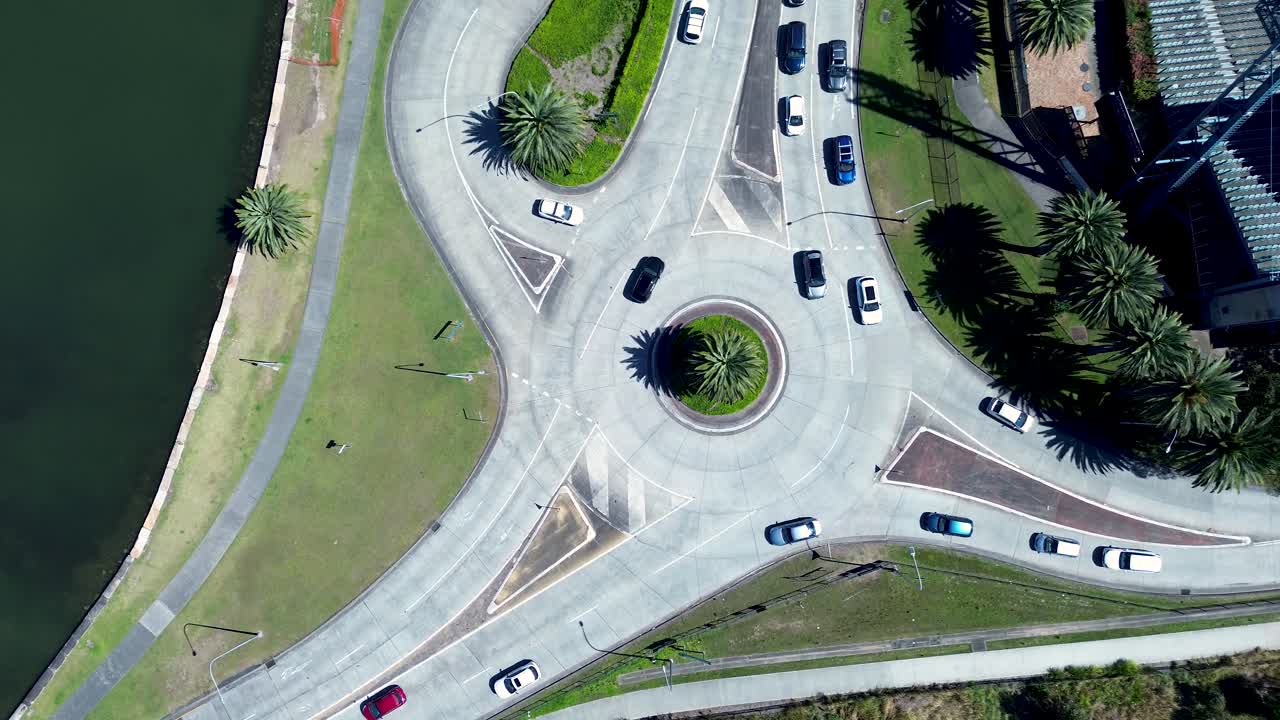 Drone aerial landscape of cars and traffic travelling around roundabout intersection on main road in Gosford city CBD with trees and stadium infrastructure Central Coast Australia travel urban tourism