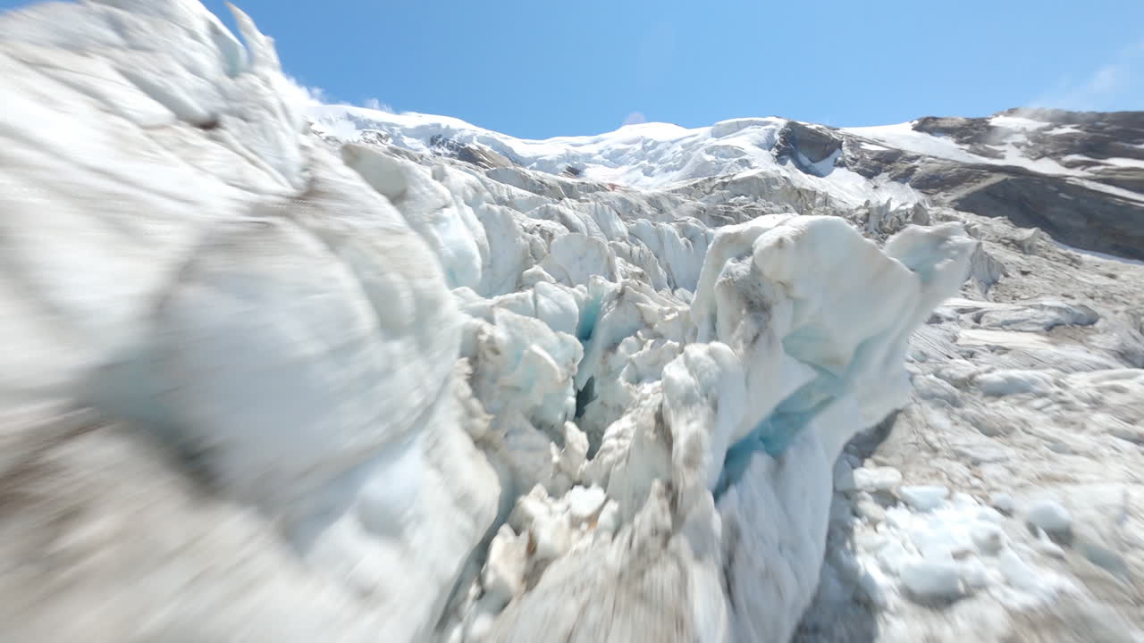 FPV drone flying through the exposed Weismies glacier above Saas-Grund, revealing deep crevasses, seracs, and signs of rapid glacial melt. The Swiss Alps in all its beauty