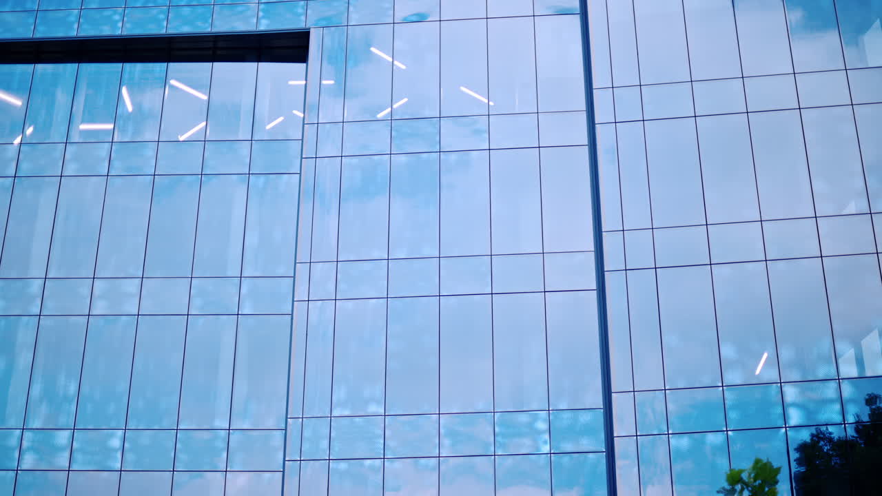 The sky being reflected on a building with glass walls