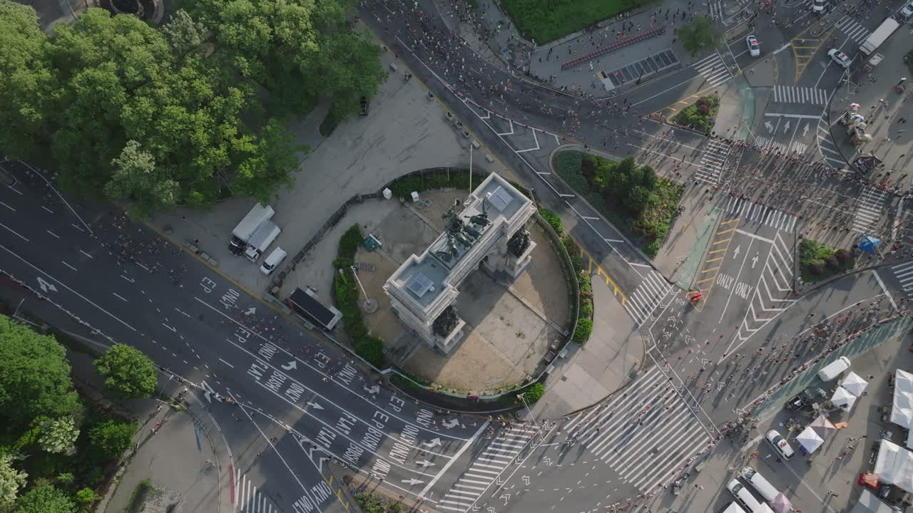 Aerial view of people running the Brooklyn Half Marathon. Shot on a summer morning at Grand Army Plaza.