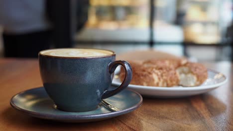 a cup of latte with pastries at a coffee shop