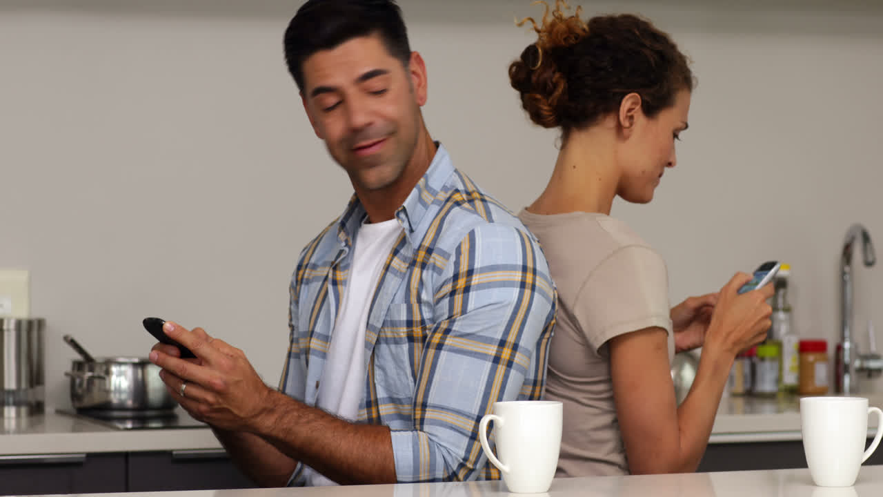 pareja sentada de espaldas a espaldas enviándose mensajes de texto