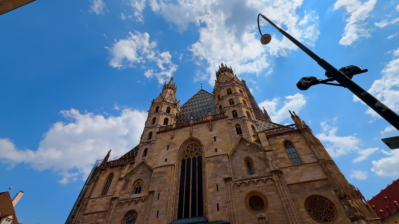Vienna, Austria - 9 giugno 2025: Gli splendidi cieli azzurri di Vienna. I turisti ammirano l'architettura mozzafiato a Vienna, Austria, con dettagliate torri gotiche che si ergono verso le nuvole