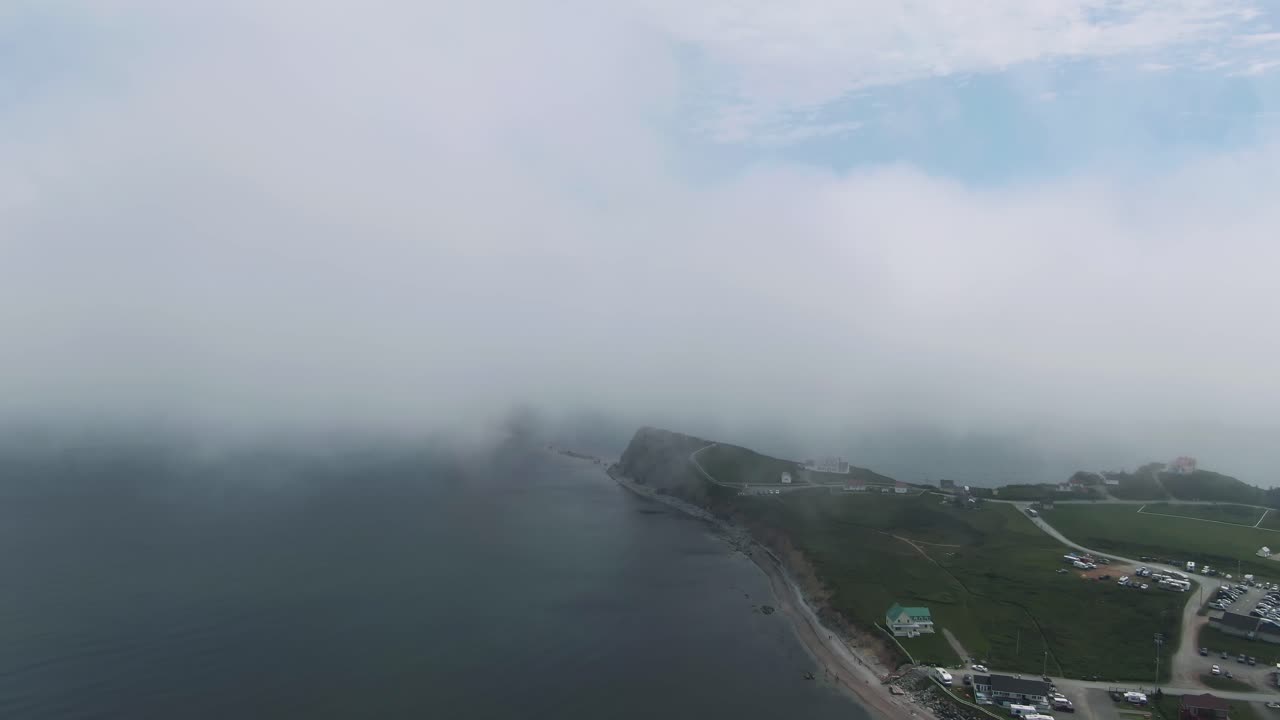 캐나다 퀘벡의 안개 낀 아침에 구름으로 뒤덮인 세인트 로렌스만의 잔잔한 물 옆에 있는 페르스 시