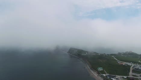 Die-Stadt-Perce-Am-Ruhigen-Wasser-Des-Golfs-Von-Saint-Lawrence,-Bedeckt-Mit-Wolken-An-Einem-Nebligen-Morgen-In-Quebec,-Kanada