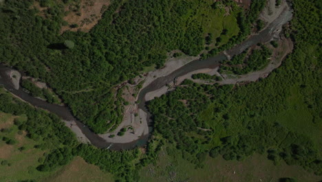 Aerial-cinematic-drone-summer-high-altitude-dirt-road-Silverton-Mountain-Ski-Resort-southern-Colorado-blue-sky-late-morning-stunning-lush-green-Rocky-Mountains-down-river-looking-down-forward-motion