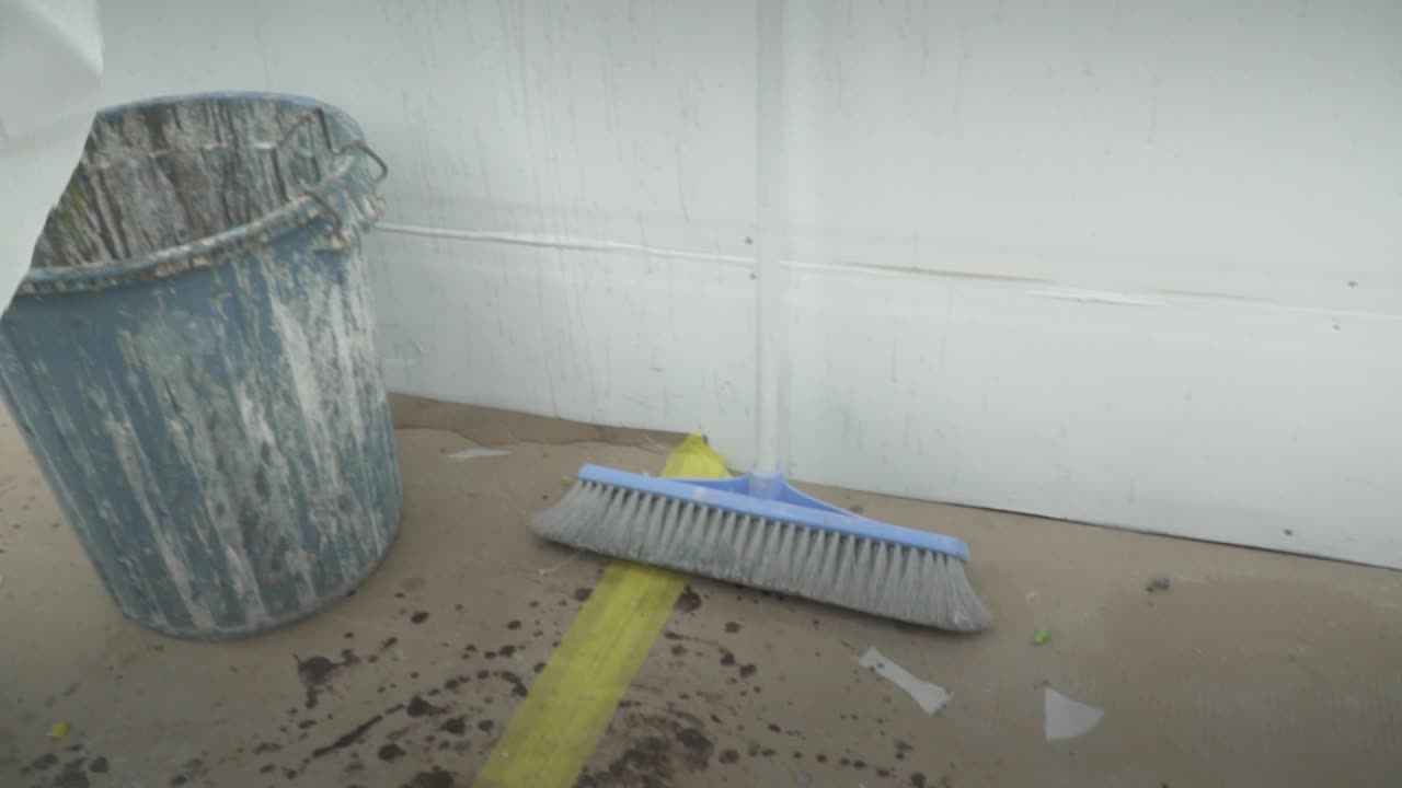 moldeador de tablas de surf en cámara lenta cortando fibra de vidrio con tijeras