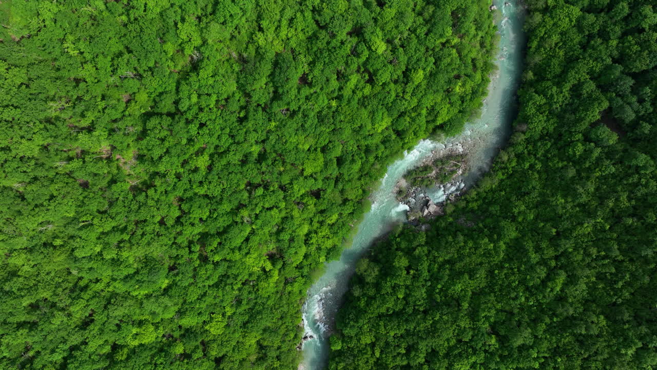 una vista de pájaro de un río de montaña salvaje de color verdoso puro