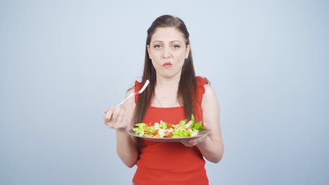 la persona que hace dieta se cansa de comer ensalada. una persona que lucha con una dieta.