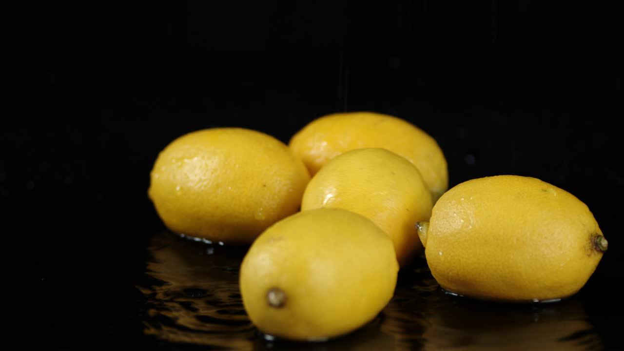 limones enteros caen en las salpicaduras de agua.