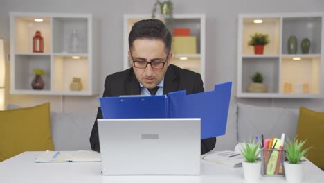 home office worker man reviewing paperwork files.