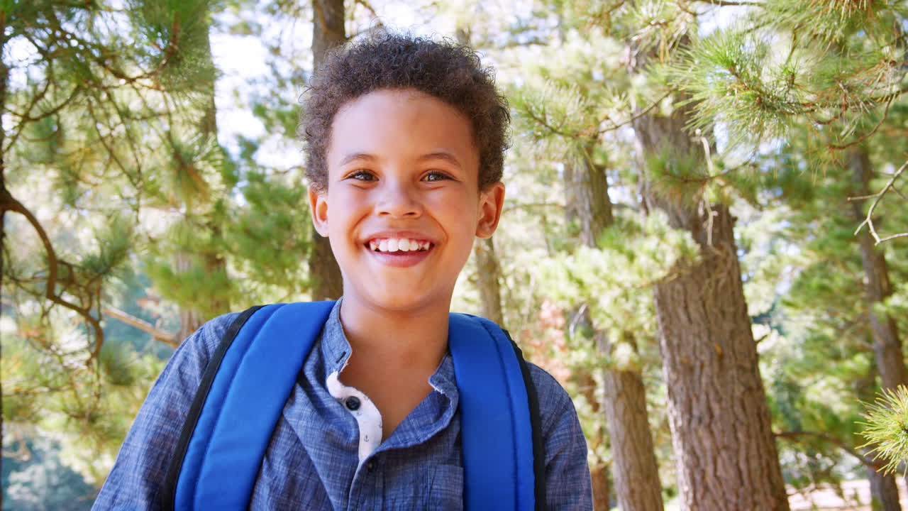 retrato de un padre caminando por el bosque llevando a su hijo en los hombros