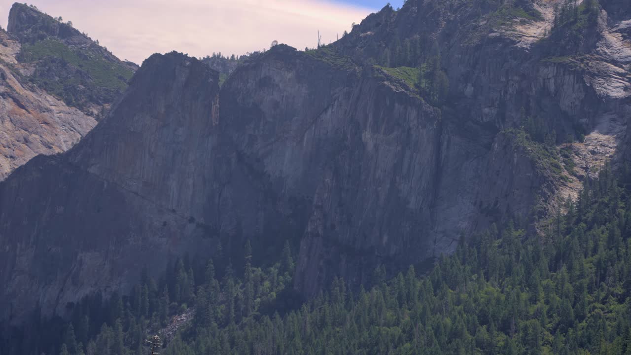 Slow zoom-out view of a massive granite cliff face in Yosemite National Park