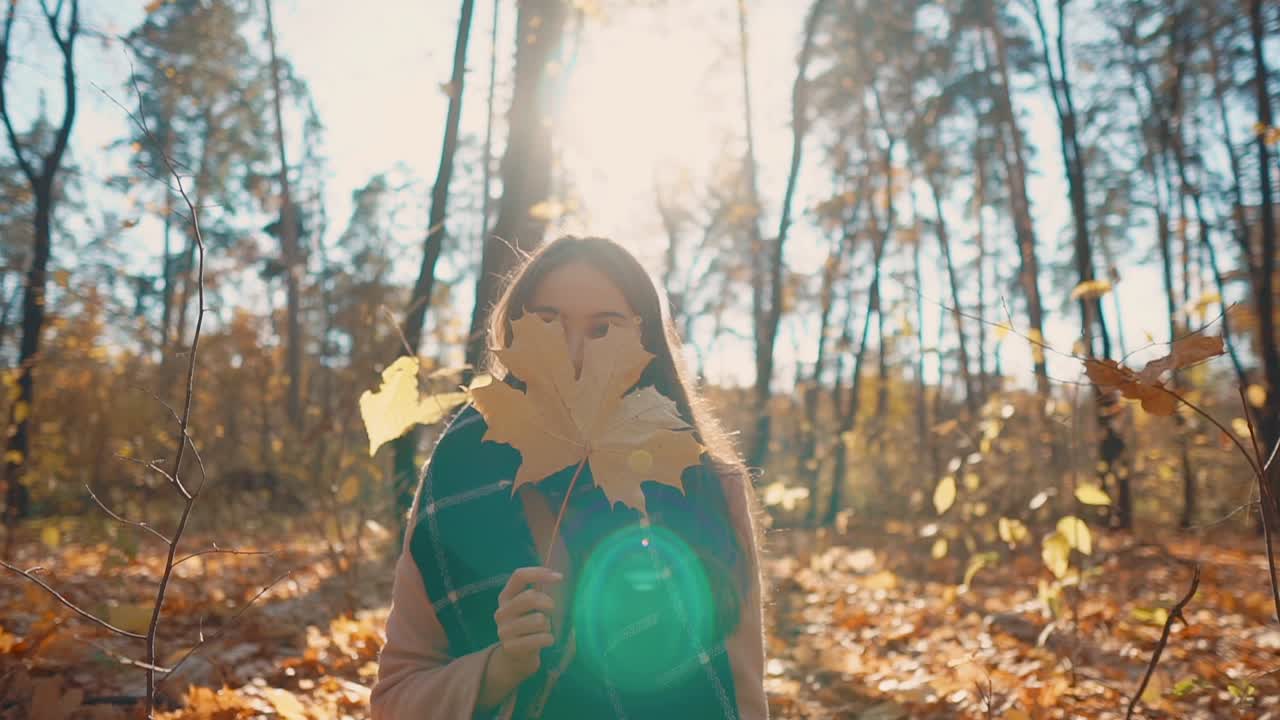 una mujer disfrutando del otoño en un bosque.