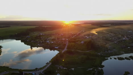 sunset over a rural village with a lakeside reflection