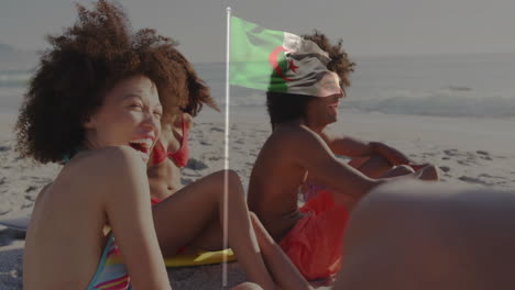 waving algerian flag, friends relaxing on beach enjoying animation in background