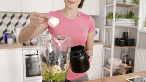 deportista preparando un batido de frutas en la cocina