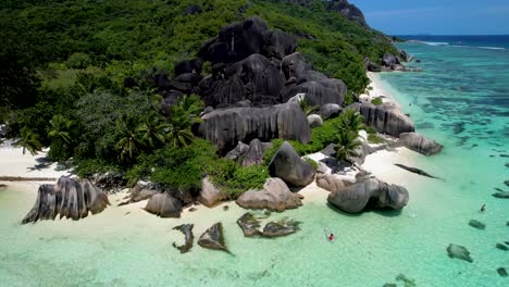 aerial view of anse source d'argent beach in the seychelles zoom in with woman in clear bottom kayak