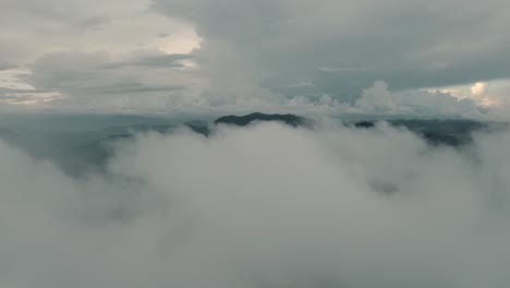 drone aerial shot flying through clouds moving fast in a misty day