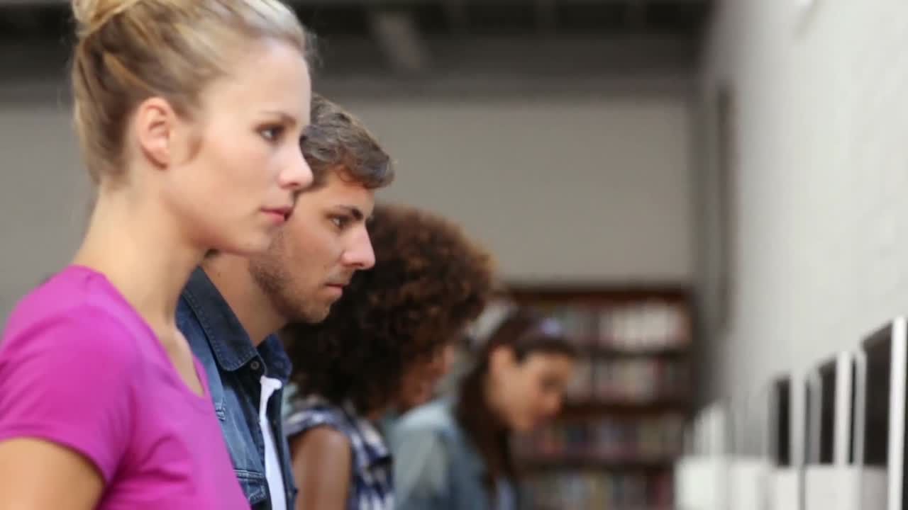 estudiantes sentados en fila trabajando en computadoras