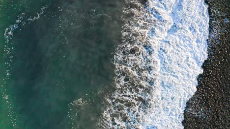 flying above black sea waves along the beach