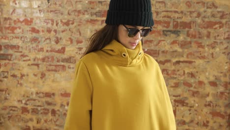 caucasian woman showing her outfit on a brick wall