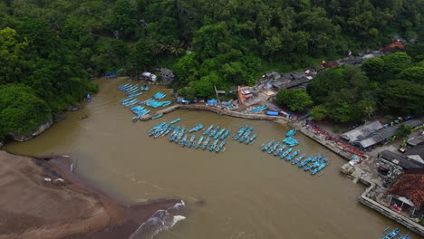vista aérea de aves de la playa de baron con puerto y barcos de pescadores flotantes en indonesia