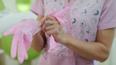 female nurse putting on health gloves. healthcare worker put on medical gloves